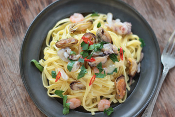 Sticker - Fettuccine with seafood, chili and parsley on a tin plate.