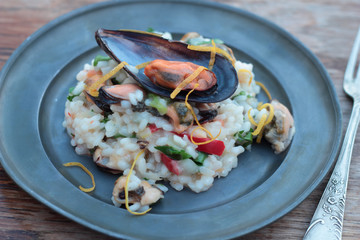 Sticker - Risotto with seafood, chili and parsley on a tin plate.