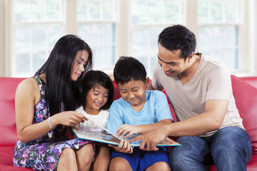 Wall Mural - Family enjoy read a story book together