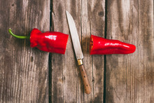 Red Pepper And Knife On Vintage Wood Table Background