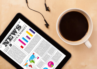 Wall Mural - tablet pc shows news on screen with a cup of coffee on a desk
