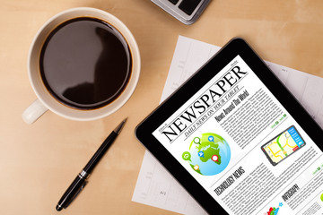 Wall Mural - tablet pc shows news on screen with a cup of coffee on a desk