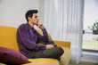 © theartofphoto - Young man sitting on couch watching television