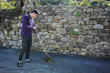 © theartofphoto - Young man outdoor sweeping foliage with broom
