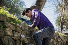 Handsome Young Man Climbing Stone Wall