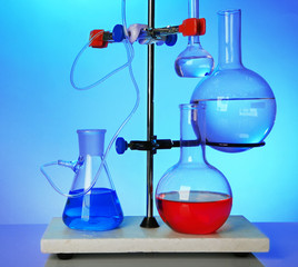 Fixed laboratory glassware on support on colorful background