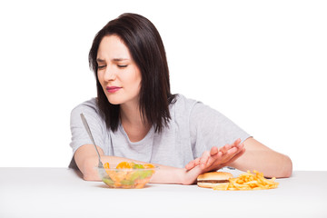 picture of woman with fruits and hamburger in front on white bac