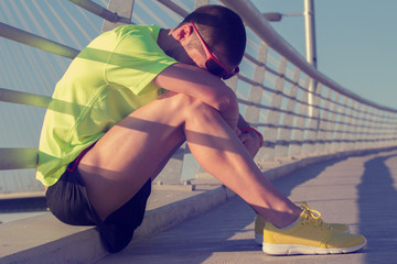 Tired/injured jogger on a big bridge.