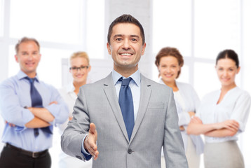 Wall Mural - happy smiling businessman in suit shaking hand