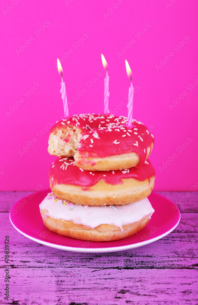 Delicious donuts with icing and birthday candles