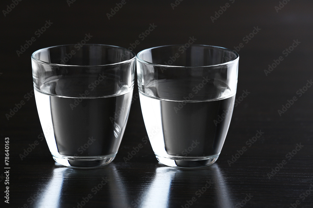 Two glasses of water on wooden background
