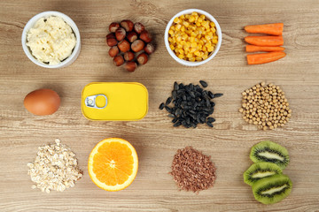 Wall Mural - Various food products containing vitamins on wooden background