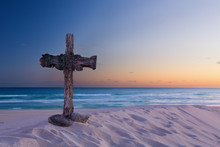 An Old Cross On Sand Dune Next To The Ocean With A Calm Sunrise