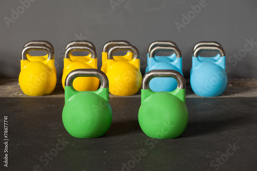 Fotografía Colorido kettlebells en una fila en un gimnasio - se centran en el frente kett