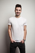 © Alex from the Rock - Smiling man in blank t-shirt, white wall background