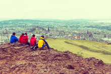 Family Enjoying View Of Edinburgh From Top Of Arthurs Seat
