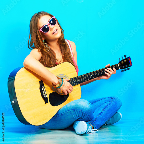 Fototapeta na wymiar young woman sings and playing guitar