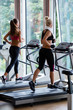 © .shock - friends exercising on a treadmill at the bright modern gym