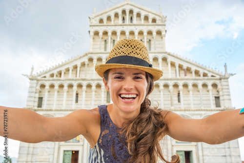 Fotografering Happy young woman making selfie in front of duomo di pisa, pisa