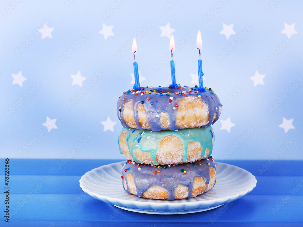 Delicious donuts with icing and birthday candles
