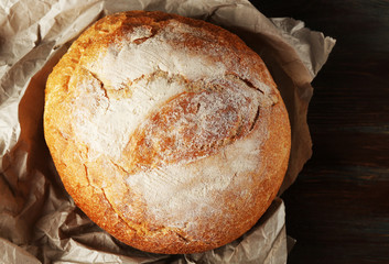 Poster - Fresh bread on paper on wooden background