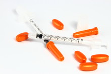 Orange Pills And Insulin Needles On White