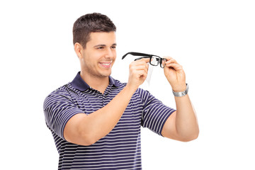 Wall Mural - Young man wiping his glasses