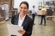 © WavebreakmediaMicro - Smiling warehouse manager writing on clipboard