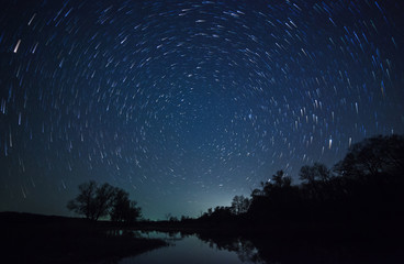 a beautiful night sky, milky way, star trails and the trees