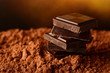 Heap of blocks of chocolate on cocoa powder