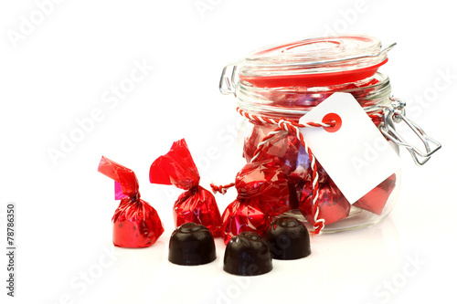 Fotografia, Obraz a glass jar full of delicious bonbons wrapped in shiny red paper