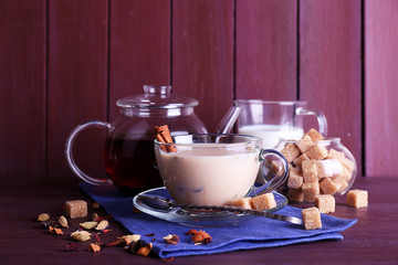 Canvas Print - Black tea with milk and lump sugar and spices  in glassware