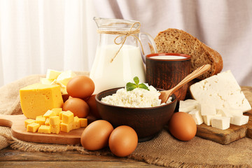 Tasty dairy products with bread on table on fabric background