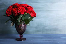 Bouquet Of Red Roses In Glass Vase On Wooden Background