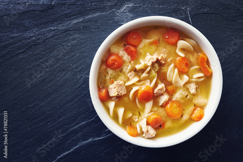 Fotografie, Obraz top down photo of chicken noodle soup with copy space on slate
