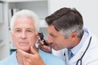 © WavebreakMediaMicro - Doctor examining senior patients ear with otoscope