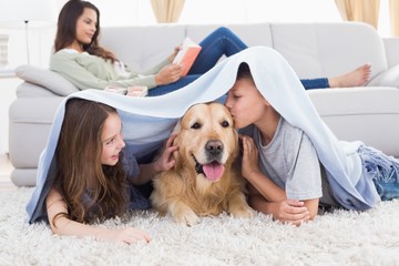 Wall Mural - Siblings with dog under blanket