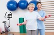 © WavebreakmediaMicro - Therapist helping senior woman fit dumbbells