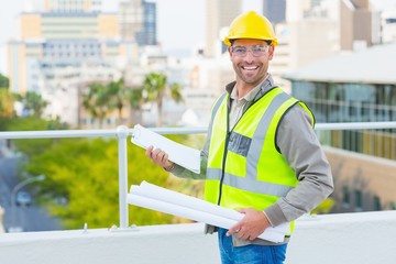 Poster - Smiling male architect with blueprints and clipboard