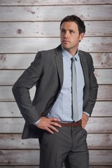 Poster - Composite image of serious businessman with hands on hips
