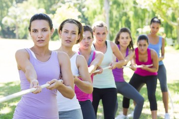 Fitness group playing tug of war