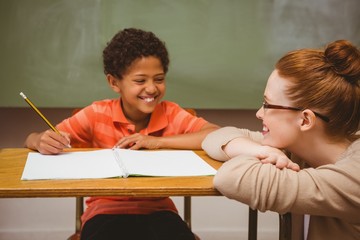 Poster - Teacher assisting boy with homework in classroom