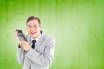 Poster - Composite image of geeky smiling businessman holding calculator