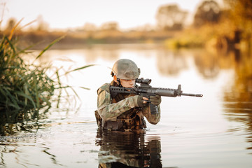 Wall Mural - Soldier moving through the water and aiming at the enemy