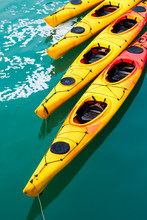 Row Of Colorful Yellow Kayaks In The Water. Top View.