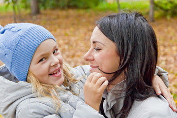 smiling mother and daughter in autumn