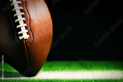 Cuadros en Lienzo American football on green grass, on black background