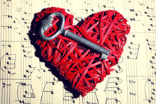 Retro Key With Wicker Heart On Music Book Background