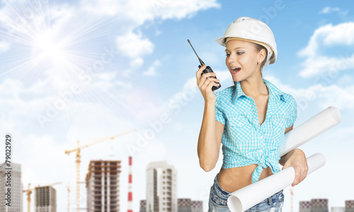 Naklejka na drzwi Woman talking on portable radio, holding roll of paper. Tower