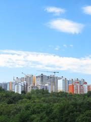 Residential modern apartment house, green forest and blue sky